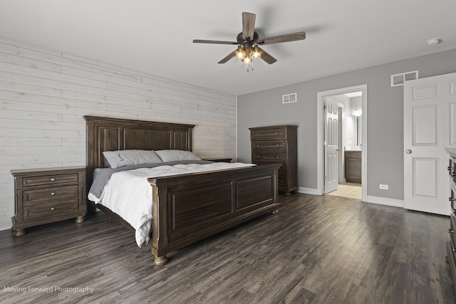 bedroom featuring dark hardwood / wood-style floors, connected bathroom, and ceiling fan