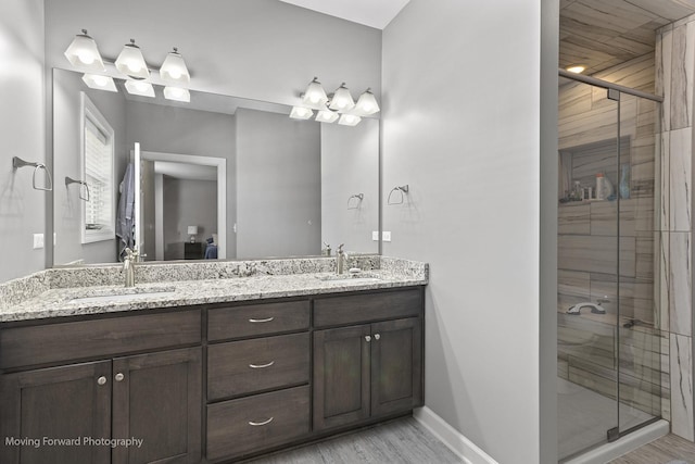 bathroom featuring a shower with door, vanity, and wood-type flooring