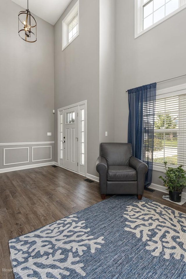 entrance foyer with an inviting chandelier, dark hardwood / wood-style flooring, and a high ceiling