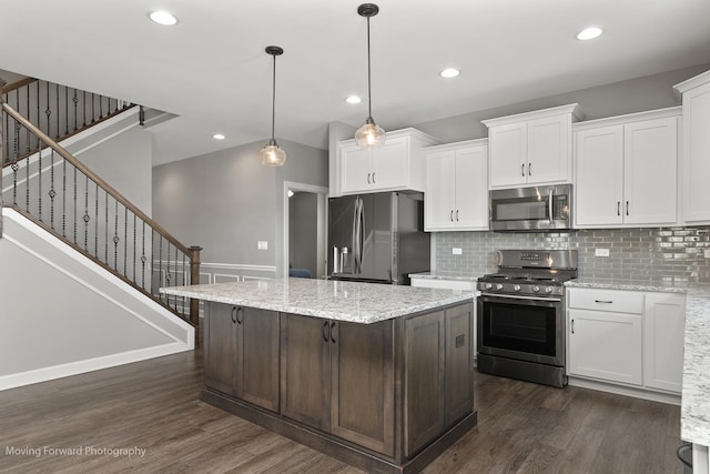 kitchen featuring decorative light fixtures, a center island, appliances with stainless steel finishes, dark hardwood / wood-style floors, and white cabinets