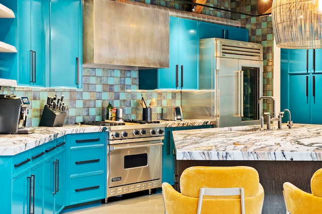 kitchen featuring backsplash, blue cabinets, and premium appliances