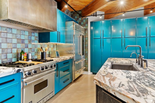 kitchen featuring high end appliances, sink, custom exhaust hood, and blue cabinetry