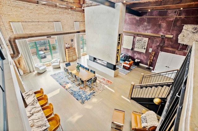 living room featuring a high ceiling and brick wall