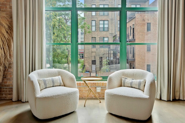 sitting room featuring brick wall