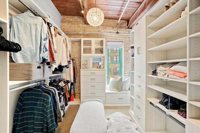 walk in closet with light hardwood / wood-style flooring