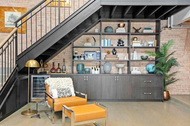 sitting room featuring wine cooler and brick wall