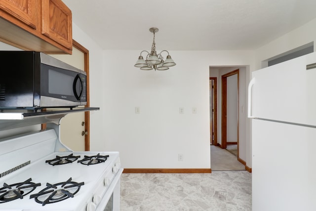 kitchen with pendant lighting, white appliances, and a chandelier