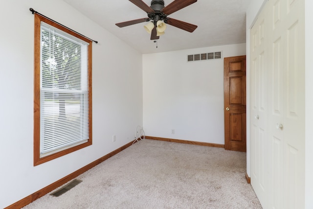 unfurnished room with light colored carpet and ceiling fan