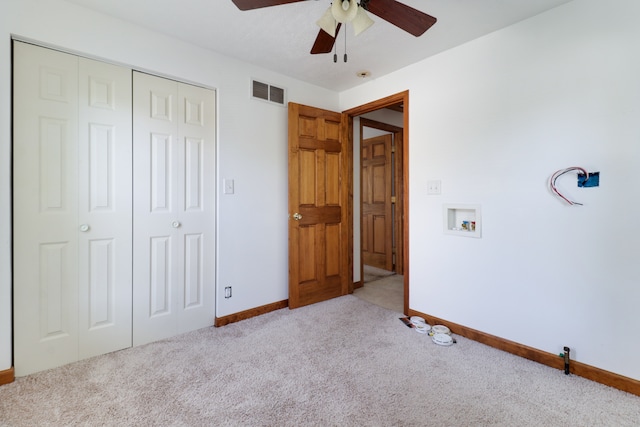 unfurnished bedroom featuring light carpet, ceiling fan, and a closet