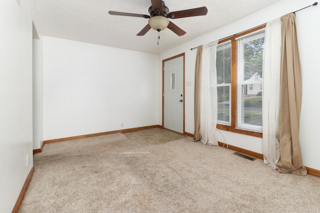 carpeted spare room with ceiling fan