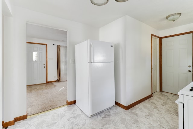 kitchen with white fridge and light carpet