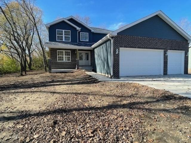 460 N School St, Braidwood, IL 60408 - view of front of home featuring an attached garage, concrete driveway, and brick siding