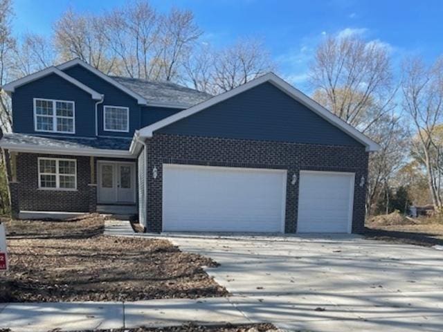 460 N School St, Braidwood, IL 60408 - view of front of house with a garage, driveway, french doors, brick siding, and a porch