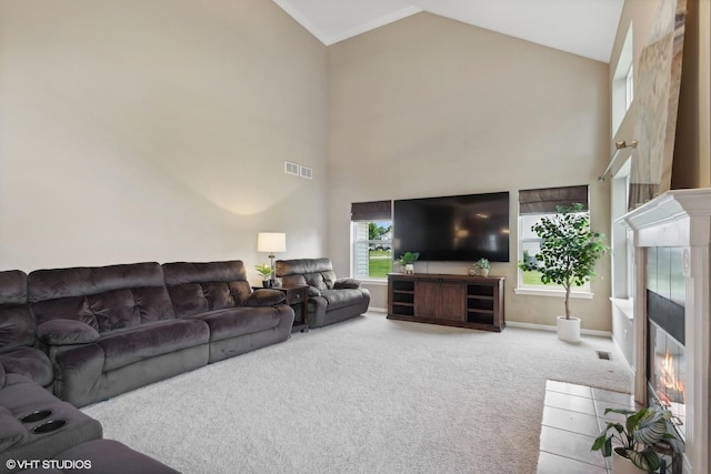 living area with high vaulted ceiling, visible vents, carpet, and a fireplace