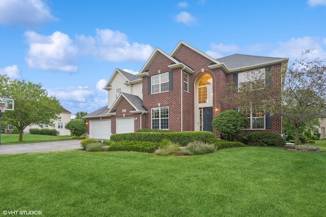 view of front of home featuring brick siding, driveway, a front yard, and a garage