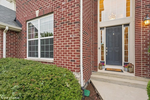 doorway to property featuring brick siding