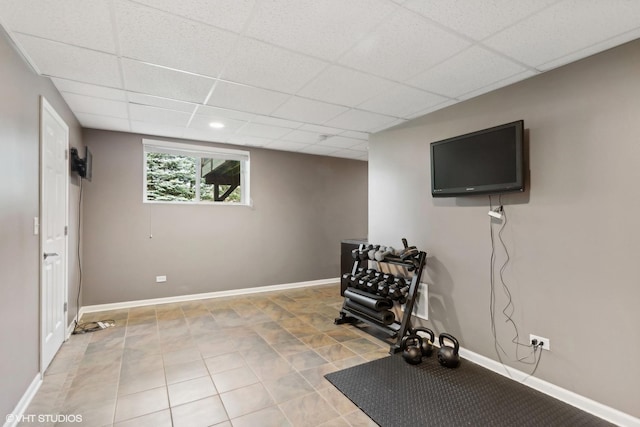 exercise area featuring light tile patterned floors, baseboards, and a paneled ceiling