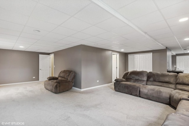 carpeted living area with recessed lighting, baseboards, and a drop ceiling