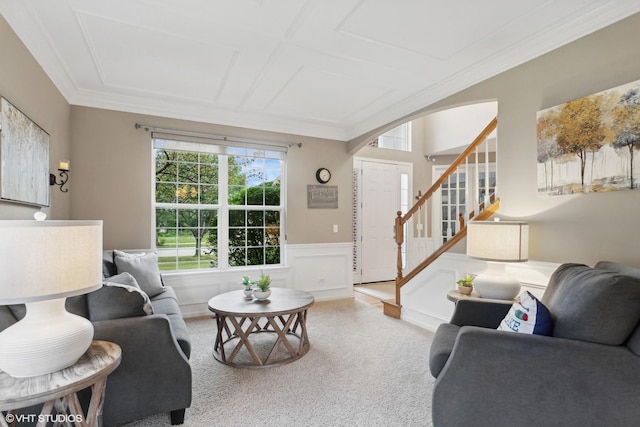 living area with carpet, a wainscoted wall, arched walkways, stairs, and crown molding