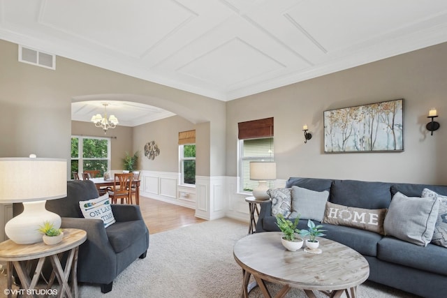 living room featuring visible vents, a wainscoted wall, arched walkways, an inviting chandelier, and light colored carpet