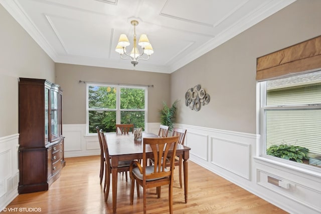 dining space featuring visible vents, ornamental molding, an inviting chandelier, wainscoting, and light wood finished floors