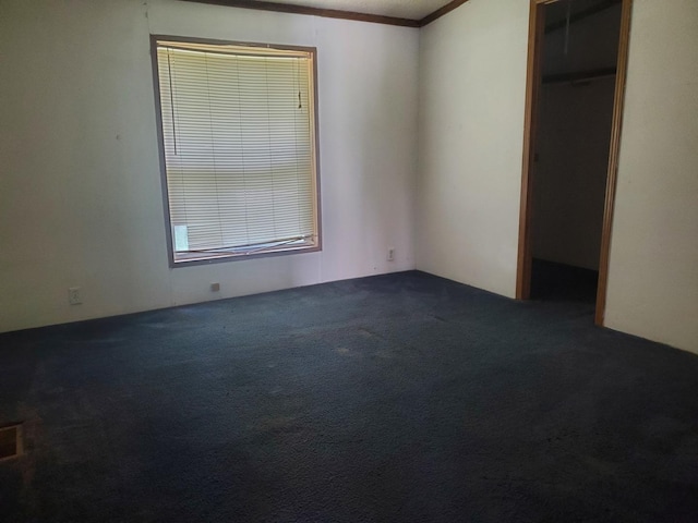 unfurnished bedroom with crown molding, dark carpet, and a closet
