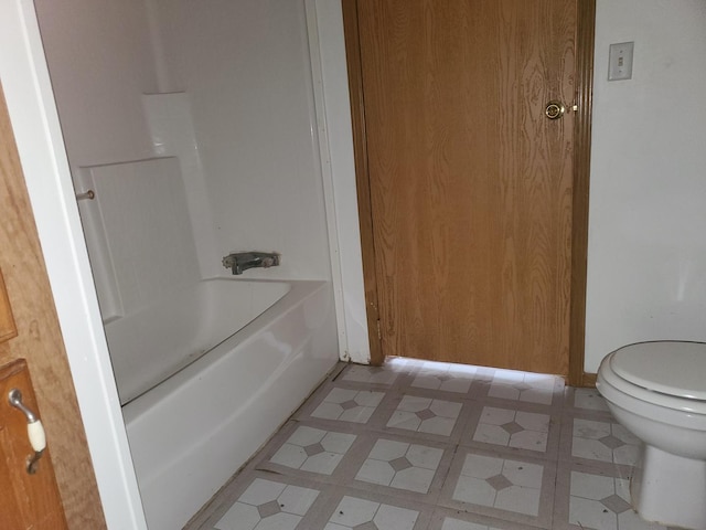 bathroom featuring shower / washtub combination and toilet