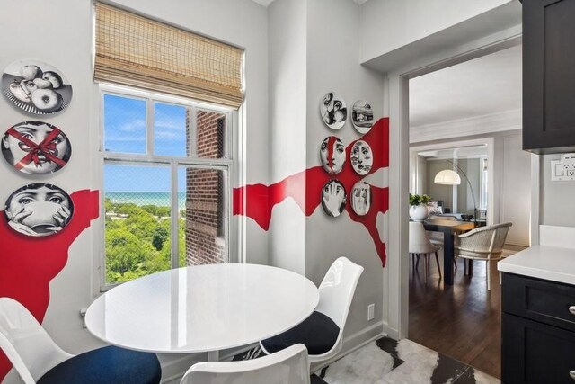 dining space featuring plenty of natural light, dark hardwood / wood-style floors, and crown molding