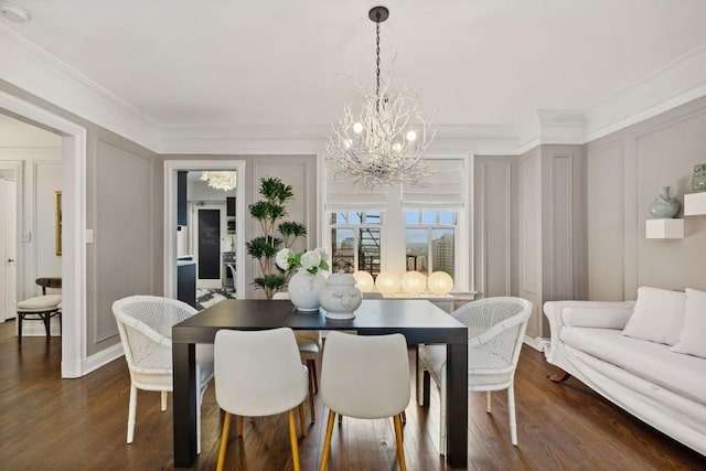 dining area with a notable chandelier, ornamental molding, and dark hardwood / wood-style floors