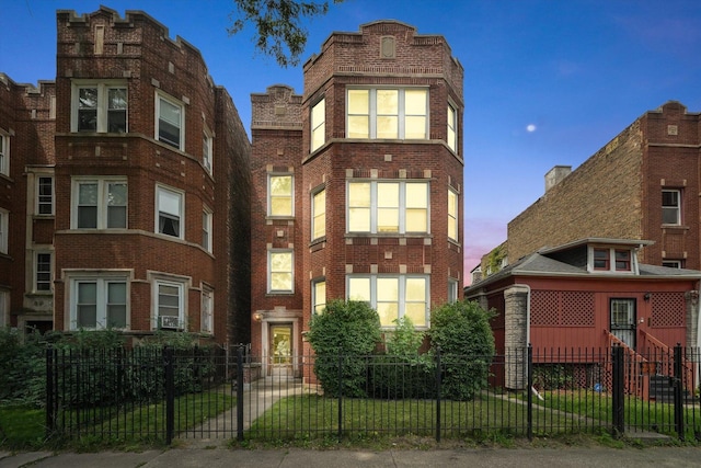 view of front of home with a fenced front yard and brick siding