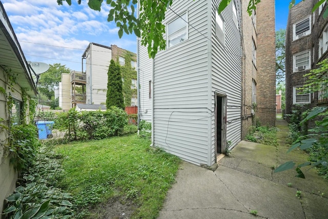 view of side of home with a yard and fence