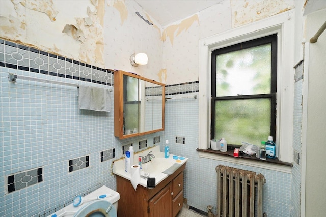 bathroom with toilet, vanity, tile walls, radiator, and wallpapered walls