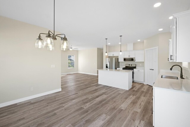 13 Starboard St, Ottawa, IL 61350 - kitchen featuring sink, appliances with stainless steel finishes, white cabinetry, a center island, and decorative light fixtures