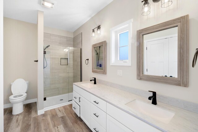 bathroom with hardwood / wood-style floors, walk in shower, dual vanity, and toilet