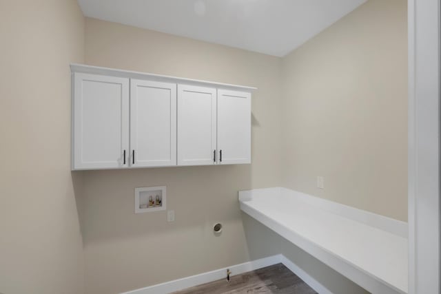 laundry room with light wood-type flooring, washer hookup, and cabinets