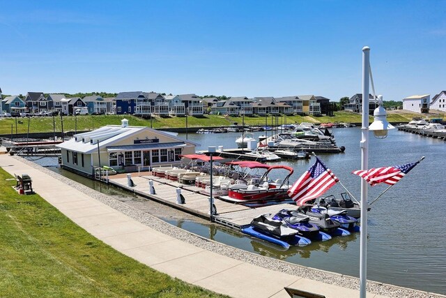 view of dock with a lawn and a water view