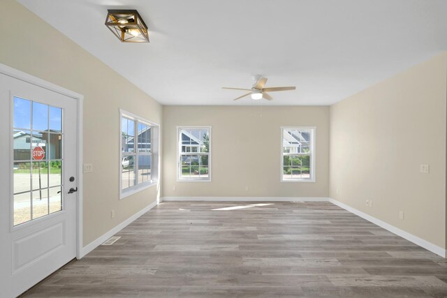 spare room featuring ceiling fan, plenty of natural light, and hardwood / wood-style flooring