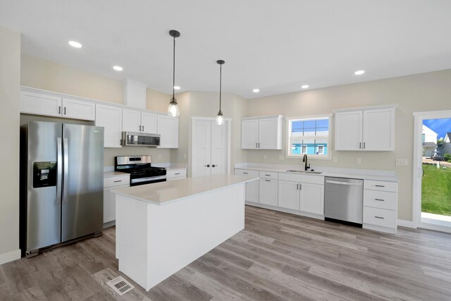 kitchen featuring light hardwood / wood-style flooring, appliances with stainless steel finishes, sink, and white cabinets