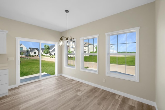 13 Starboard St, Ottawa, IL 61350 - unfurnished dining area featuring a notable chandelier, light hardwood / wood-style floors, and a wealth of natural light