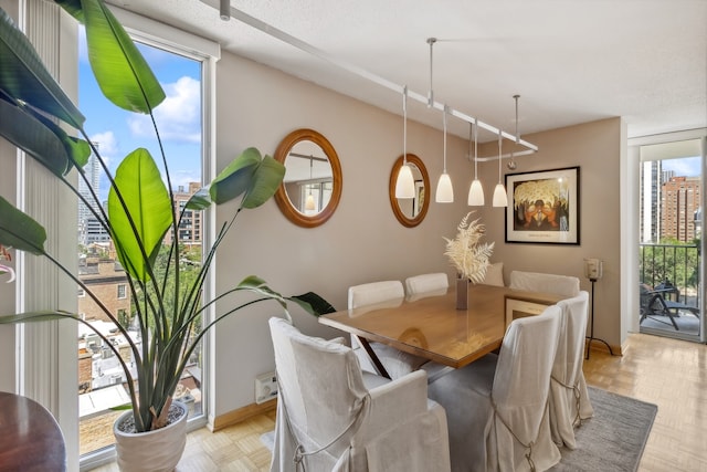 dining space featuring light parquet floors and a textured ceiling