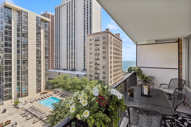 balcony featuring a pool and a water view