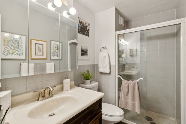 bathroom featuring a shower with door, backsplash, toilet, vanity, and tile walls