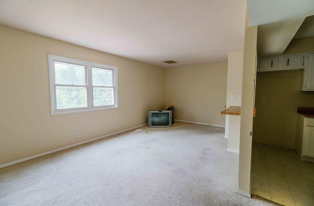 carpeted spare room featuring a textured ceiling