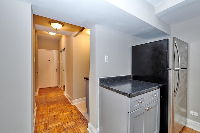 kitchen with light parquet floors and stainless steel refrigerator