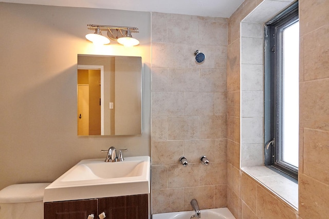 full bathroom with tiled shower / bath combo, vanity, and toilet