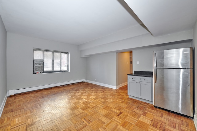 kitchen featuring light parquet floors, baseboard heating, and stainless steel fridge