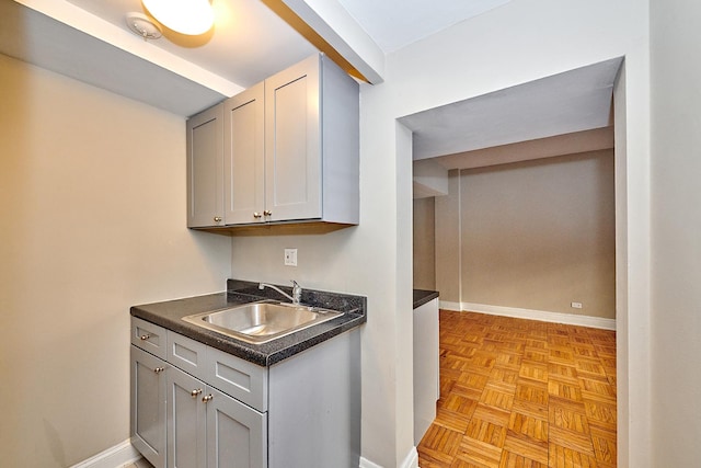 kitchen with light parquet flooring, sink, and gray cabinetry