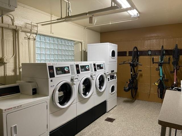 washroom with stacked washer / drying machine and washing machine and dryer