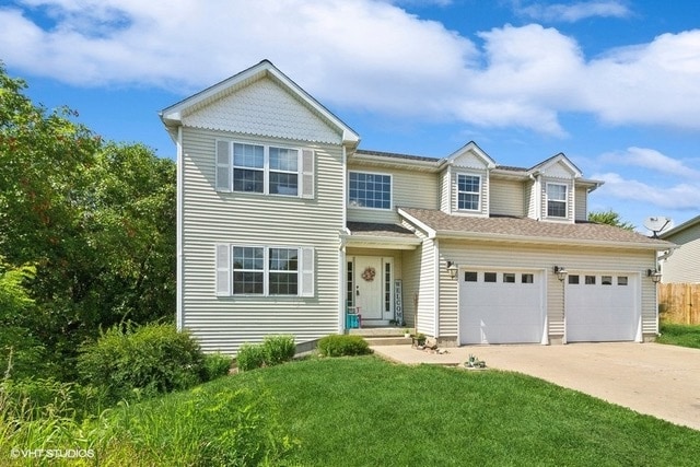 view of front of house featuring a garage and a front lawn