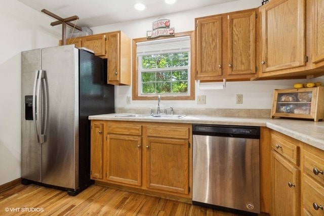 kitchen featuring light hardwood / wood-style floors, appliances with stainless steel finishes, and sink